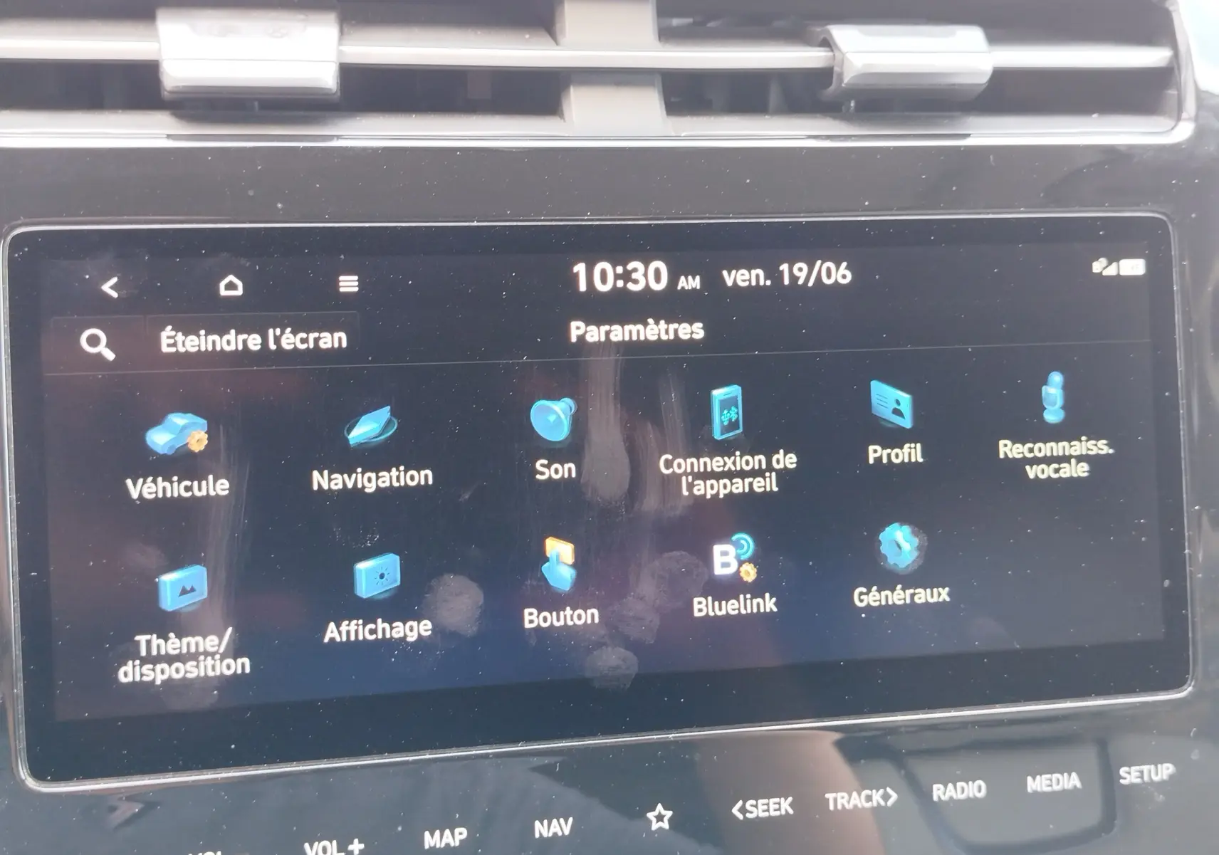 Écran tactile central du Hyundai Tucson 2021 affichant le menu des paramètres avec icônes bleues sur fond noir.