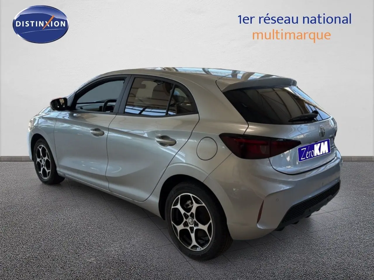 Vue 3/4 arrière droite de la MG3 Cosmic Silver Metal avec jantes alliage et vitres teintées dans un showroom.