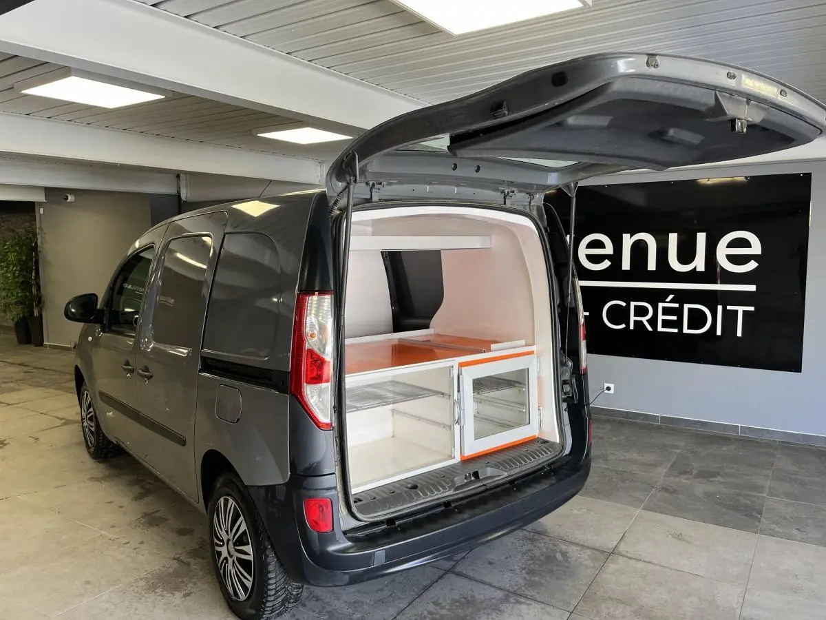 Vue 3/4 arrière gauche d'un Renault Kangoo Express gris foncé avec hayon arrière ouvert montrant l'espace de chargement aménagé.