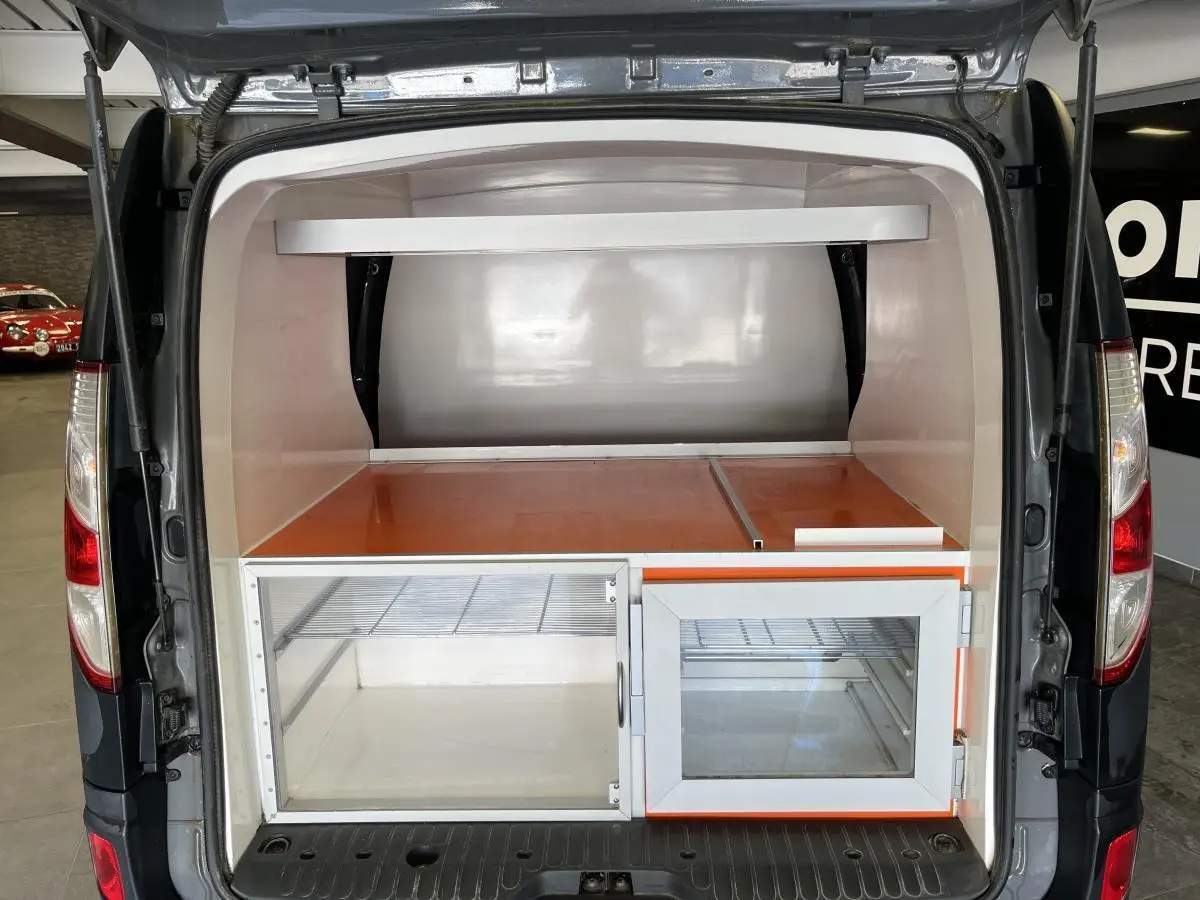 Vue arrière du Renault Kangoo Express gris foncé avec aménagement intérieur de rangement vitré et compartiment orange.