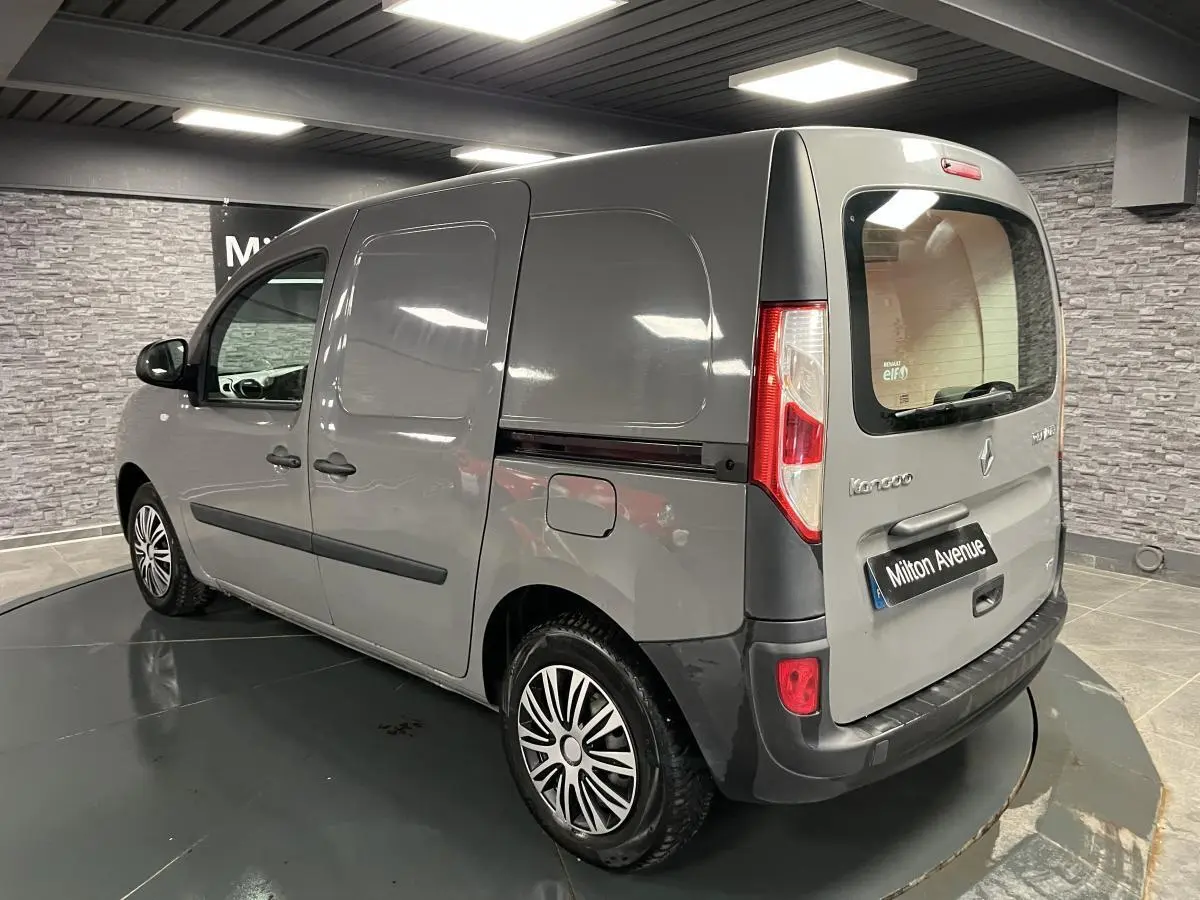 Renault Kangoo Express gris foncé vu en 3/4 arrière droit, avec hayon vitré et baguettes latérales noires.
