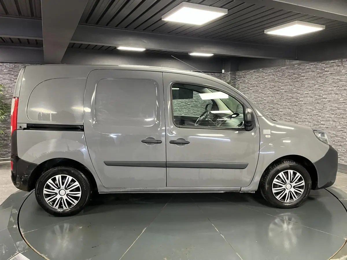 Profil droit d'un Renault Kangoo Express gris foncé avec portes latérales coulissantes tôlées et enjoliveurs noirs.