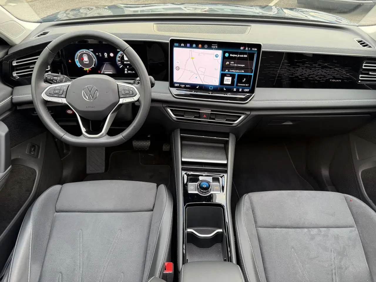 Vue intérieure avant du Volkswagen Tiguan 2024 avec tableau de bord numérique et écran tactile central lumineux.