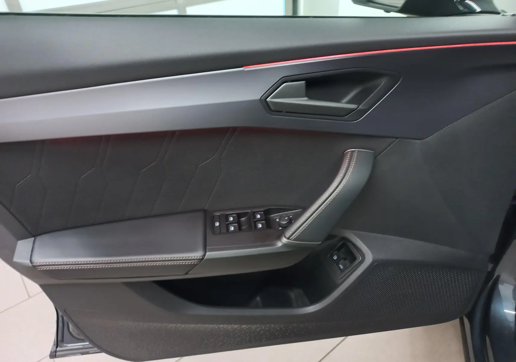 Vue rapprochée de la porte intérieure côté gauche de la CUPRA Formentor 1.5 EHybrid 2025 avec garniture noire et surpiqûres.