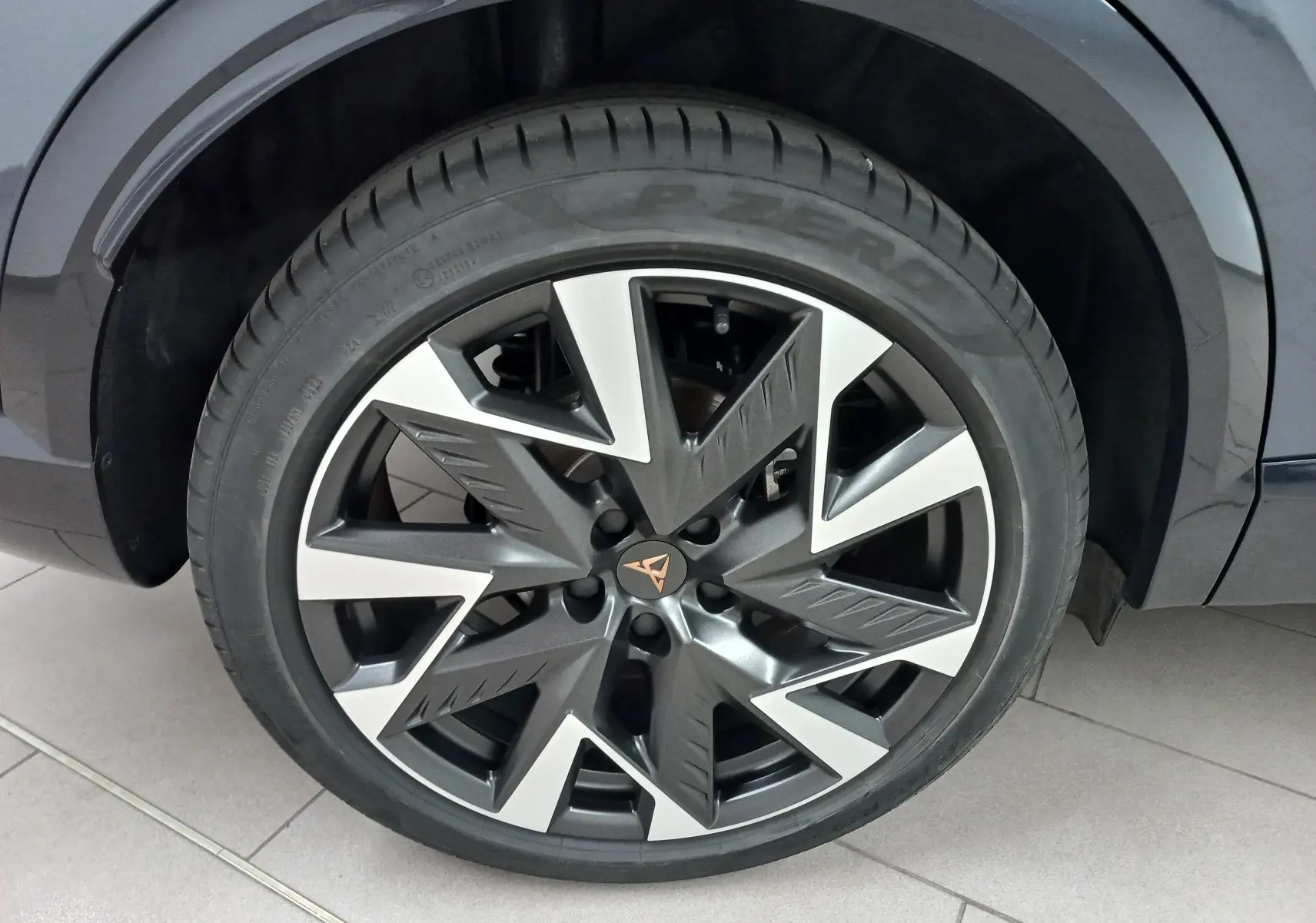 Gros plan sur la roue avant droite de la CUPRA Formentor gris magnétique, mettant en valeur la jante au design géométrique bicolore.
