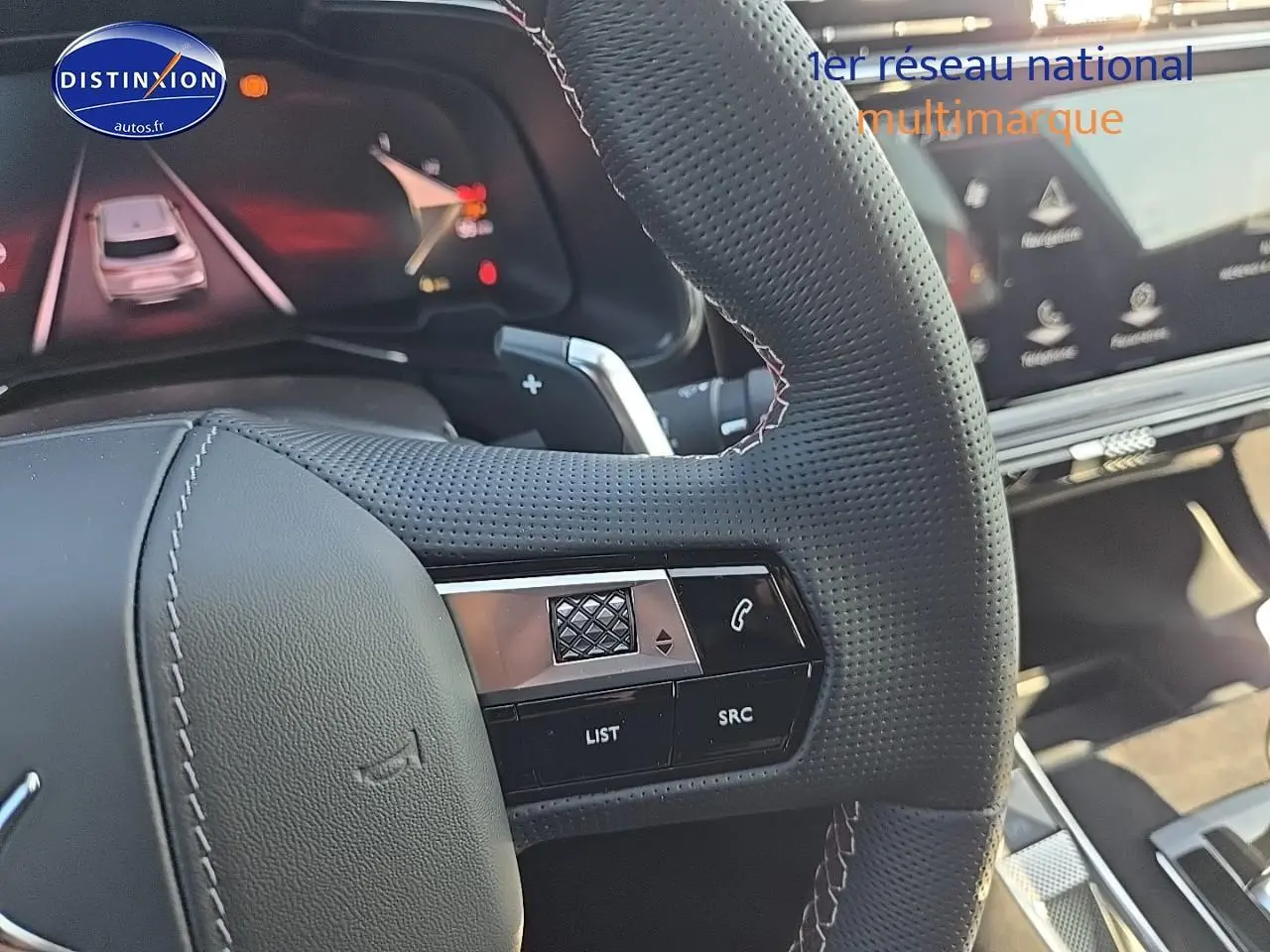 Gros plan sur le volant perforé du DS7 Cristal Pearl 2025 avec commandes intégrées et tableau de bord numérique visible.