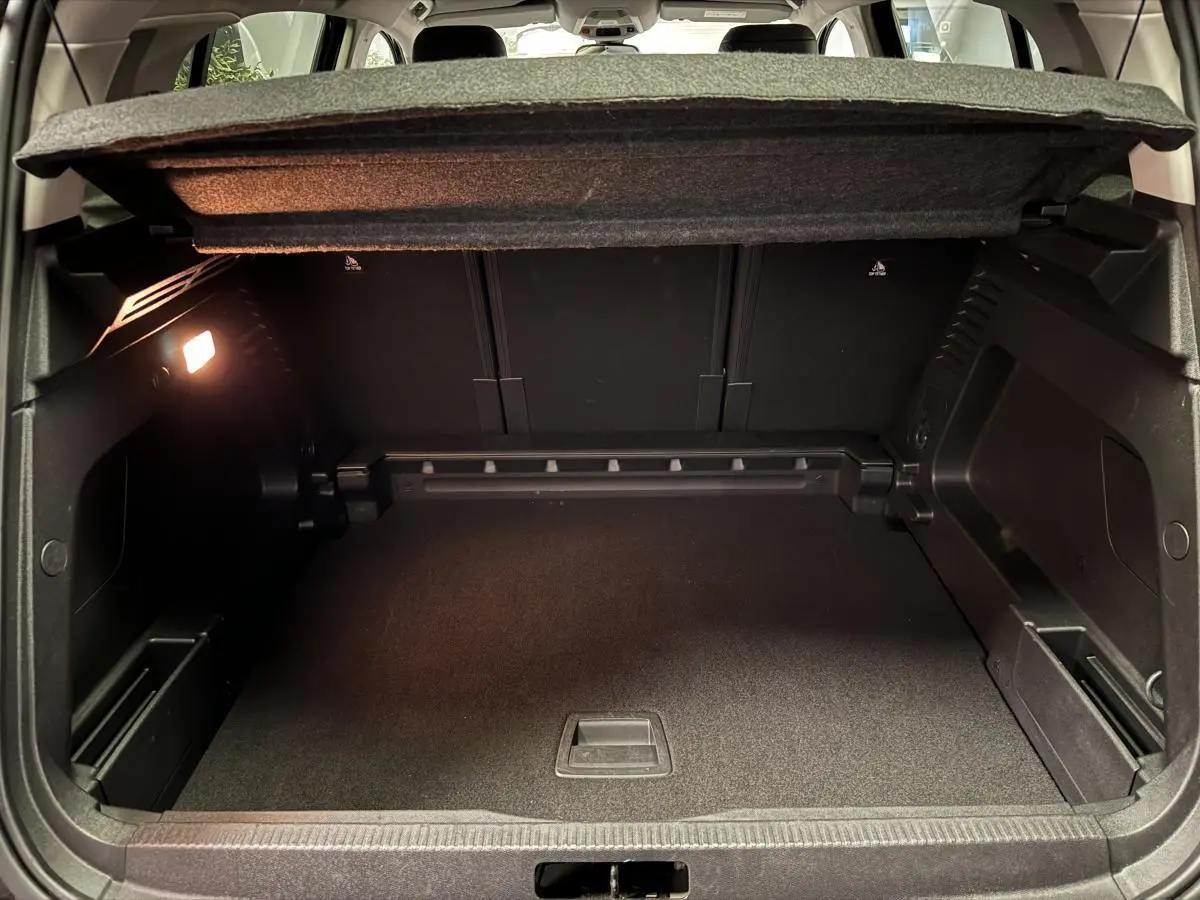 Coffre ouvert du Citroën C5 Aircross noir, montrant l'espace de chargement et la tablette cache-bagages relevée.