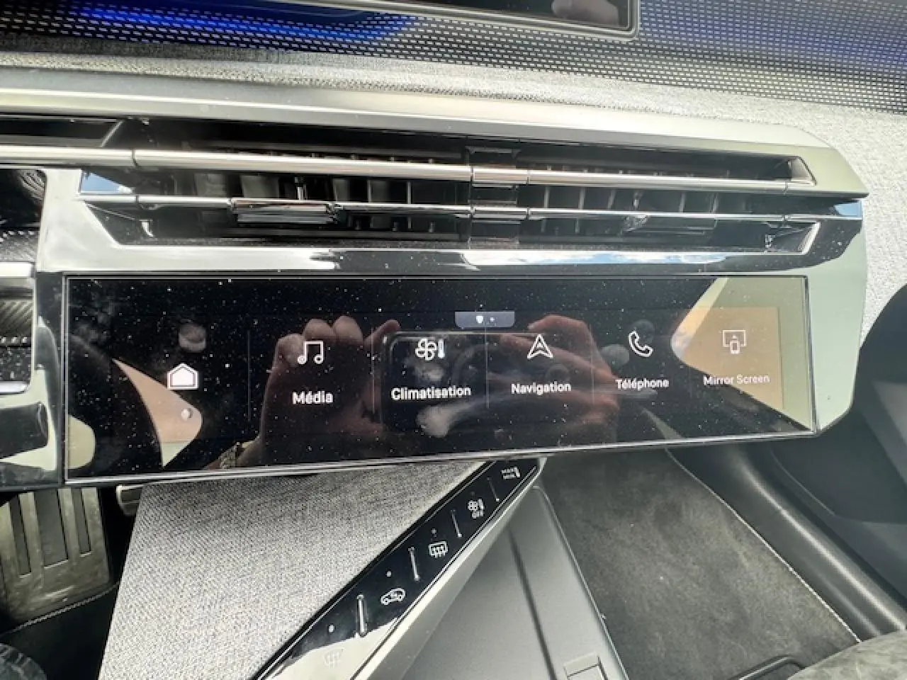 Écran tactile central du tableau de bord du Peugeot 3008 blanc nacré, avec commandes multimédia et climatisation visibles.