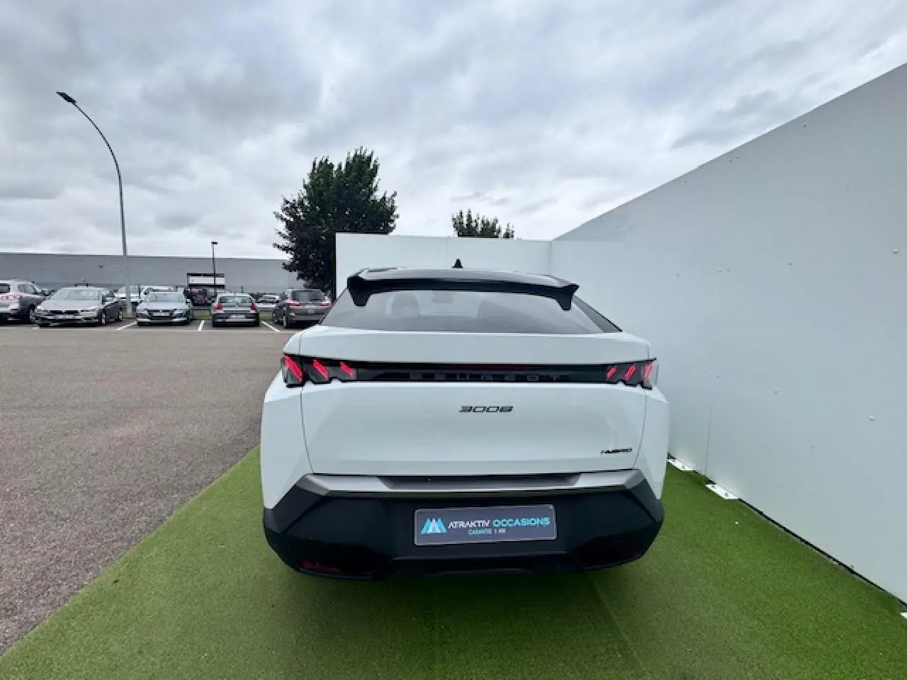 Vue arrière d'un Peugeot 3008 blanc nacré avec toit noir, feux arrière à griffes LED et bandeau noir laqué.