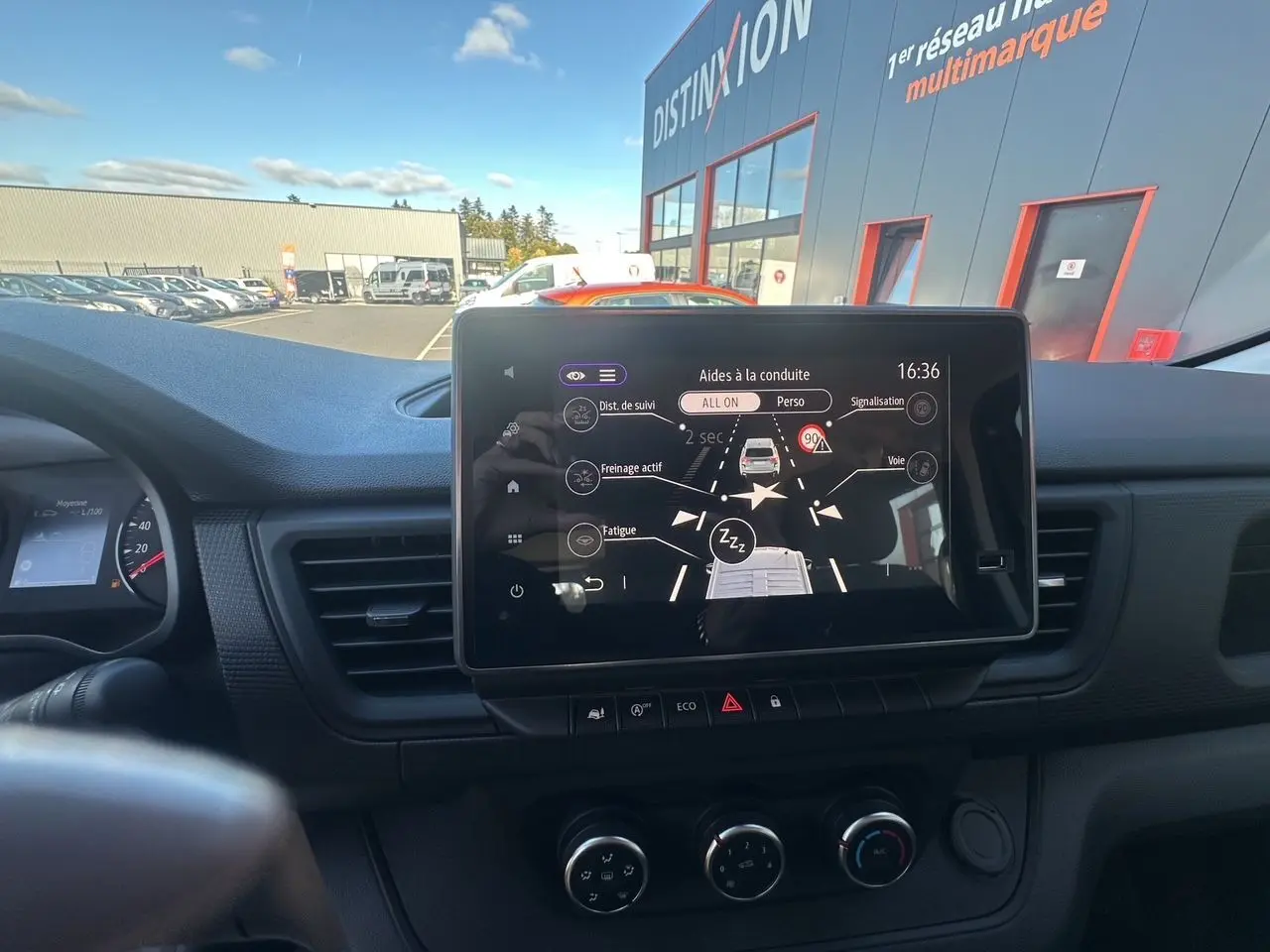 Écran tactile central du tableau de bord du Renault Trafic Combi gris, avec affichage des aides à la conduite.