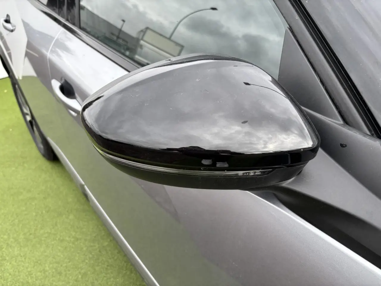 Rétroviseur côté gauche noir brillant sur Peugeot 2008 gris Artense avec toit noir, vue rapprochée en extérieur.