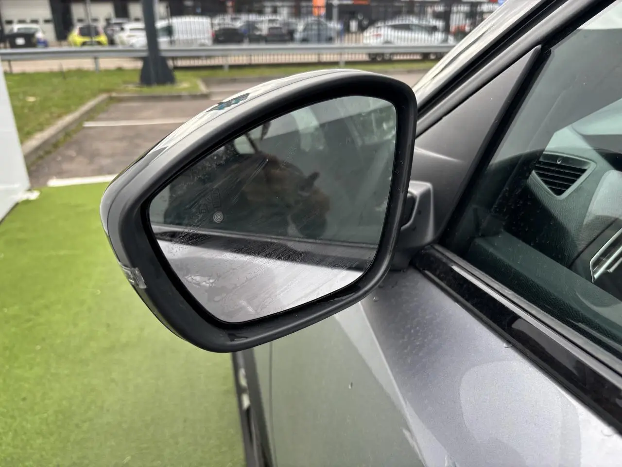 Rétroviseur côté gauche du Peugeot 2008 gris Artense avec toit noir, vue rapprochée sur la portière avant.