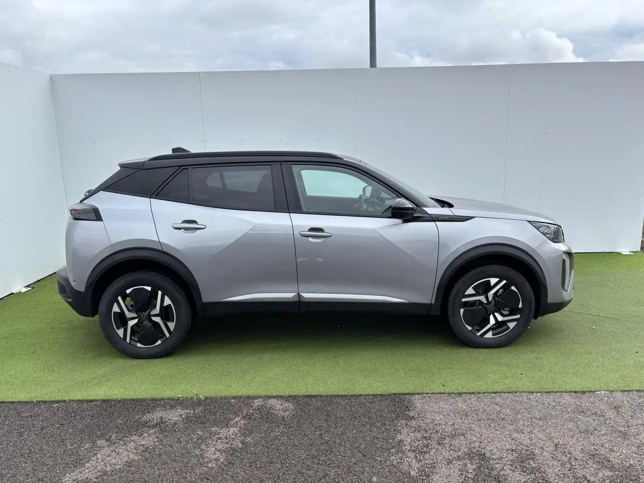 Peugeot 2008 gris Artense toit noir en vue profil côté gauche sur fond neutre extérieur.