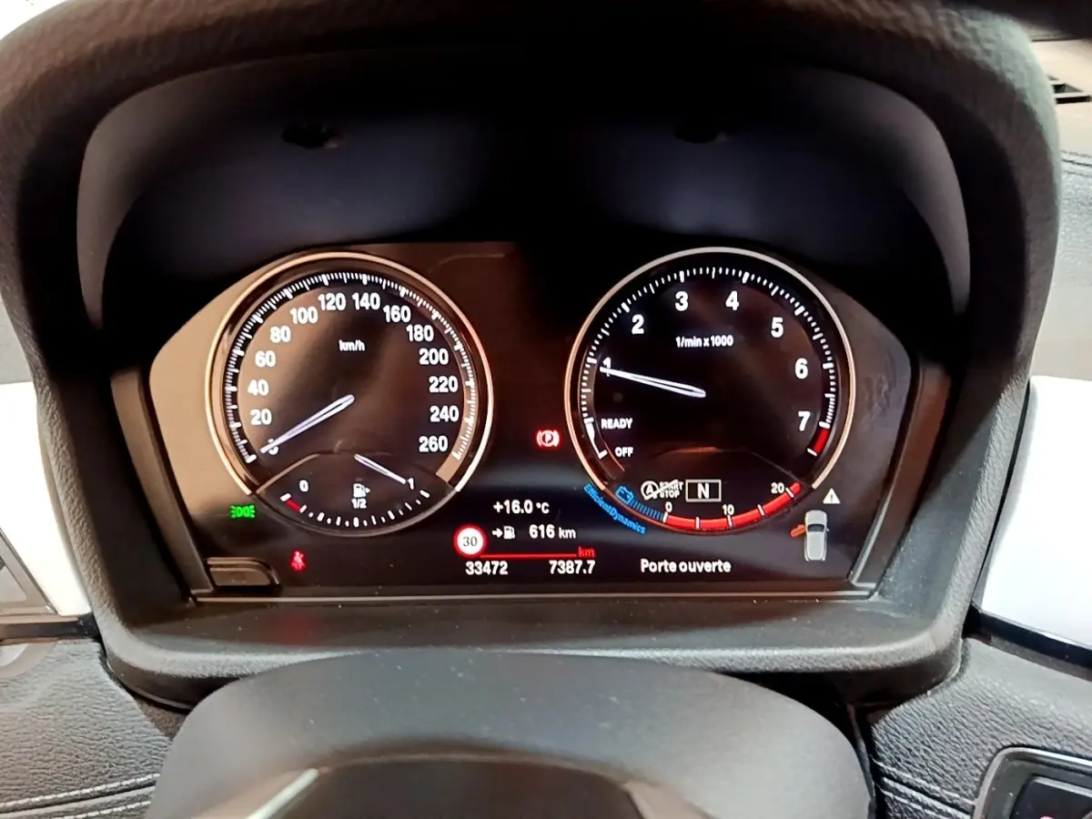 Vue rapprochée du tableau de bord numérique du BMW X2 sDrive18i 2023, affichant vitesse et compte-tours.