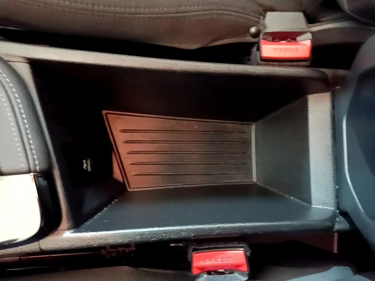 Gros plan de la console centrale noire du BMW X2 sDrive18i Lounge 2023 avec boutons de ceinture rouges visibles.