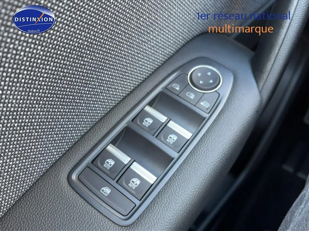 Gros plan sur les commandes des vitres électriques côté gauche d'une Renault Captur bleu iron toit noir.