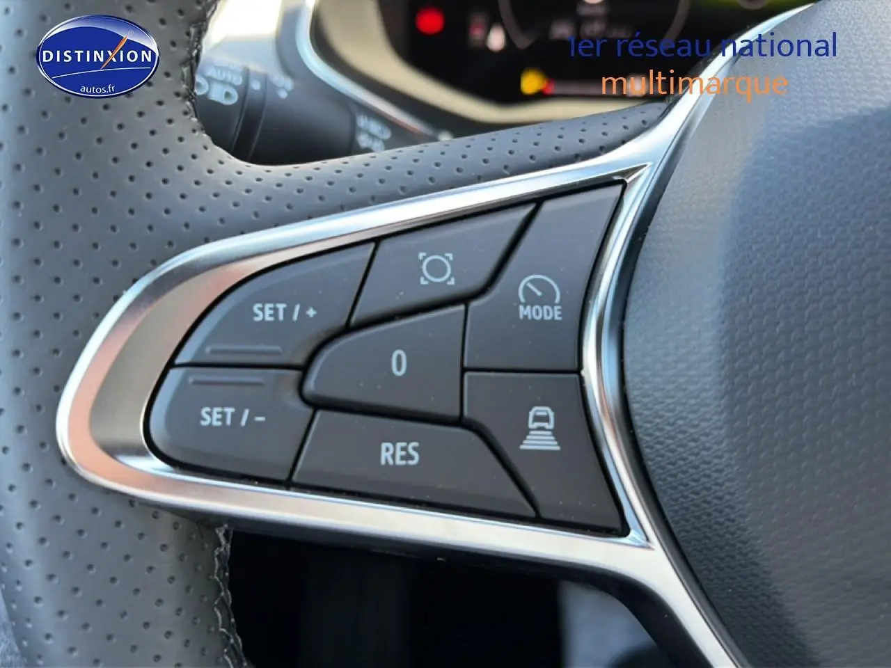 Gros plan sur les commandes multifonctions à gauche du volant perforé du Renault Captur bleu iron 2026.