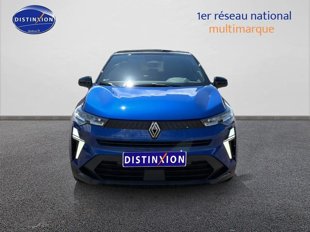 Vue avant d'un Renault Captur 1.8 e-tech hybride bleu iron avec toit noir et feux LED en forme de C.