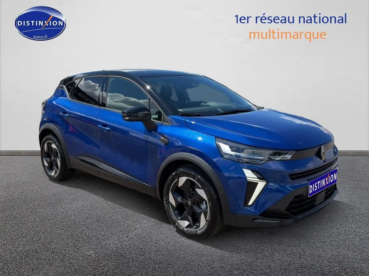 Renault Captur 2026 bleu iron toit noir en 3/4 avant, avec jantes alu et feux LED distinctifs.