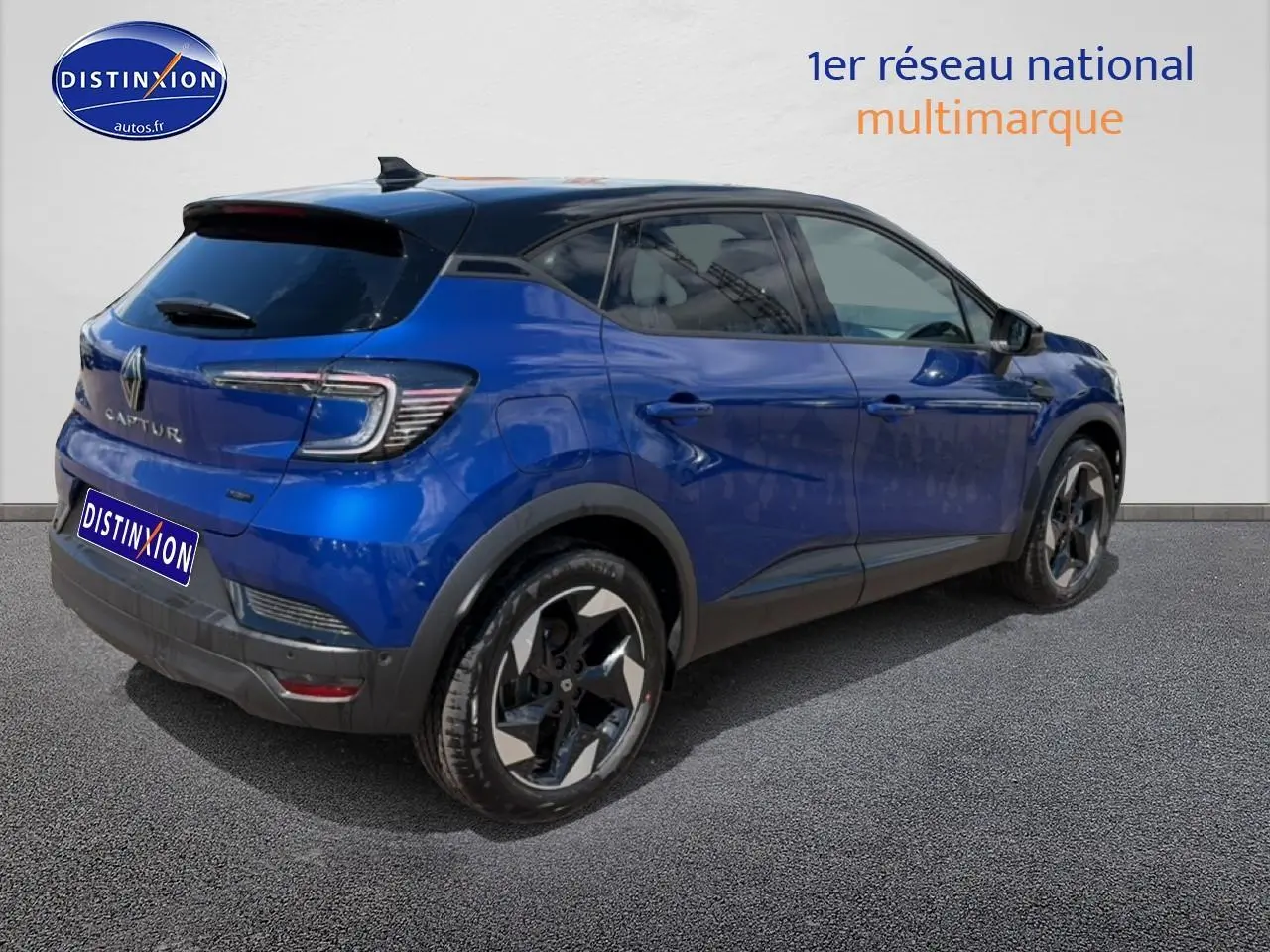 Vue 3/4 arrière droite d'un Renault Captur bleu iron avec toit noir et jantes alu distinctives.
