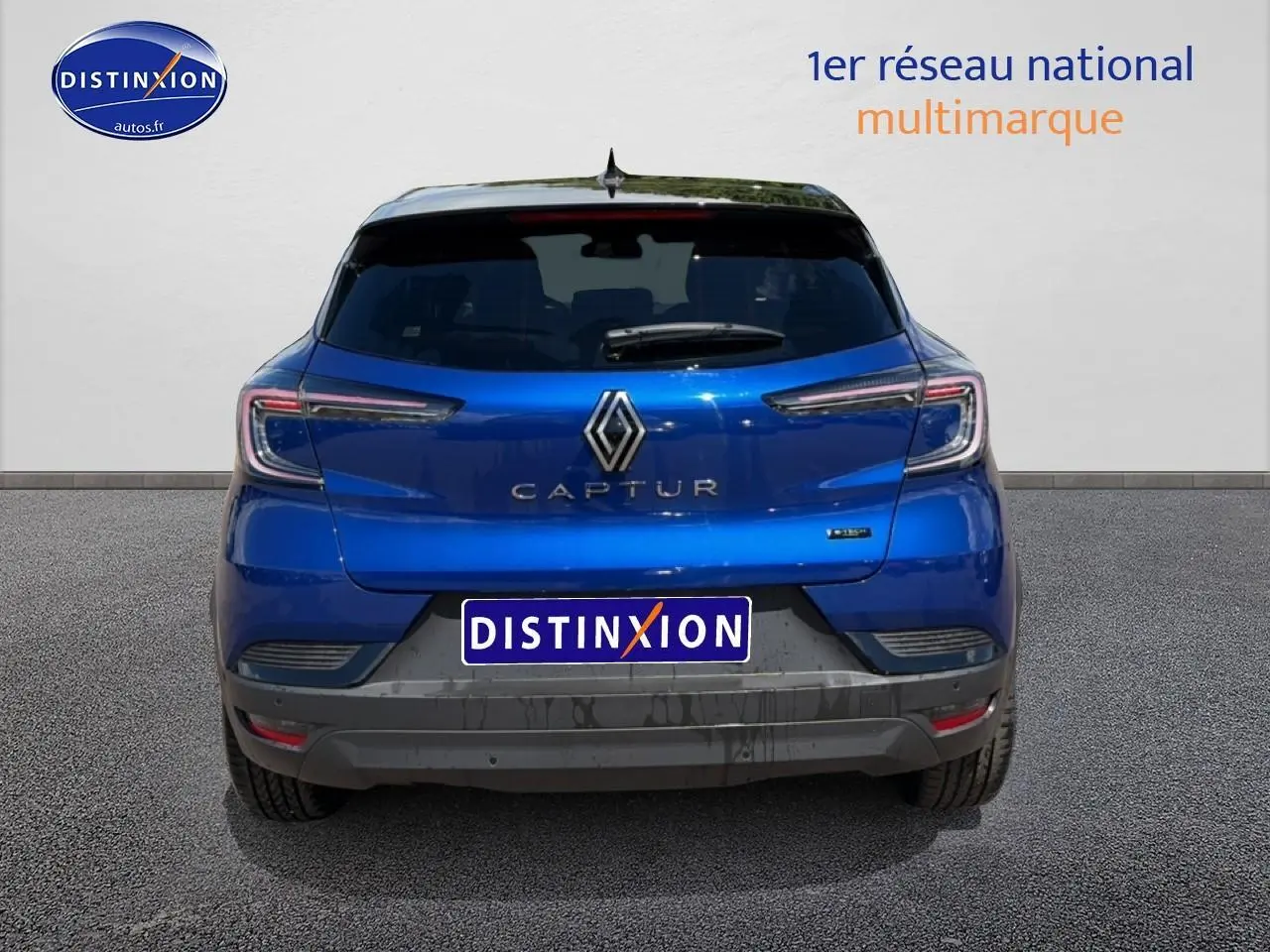 Vue arrière d'un Renault Captur bleu iron avec toit noir, mettant en valeur ses feux arrière LED et son logo central.