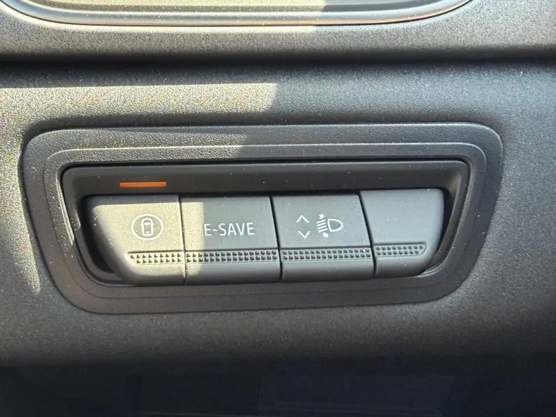 Gros plan sur les boutons de commande E-SAVE et réglage des phares du tableau de bord noir du Renault Captur blanc nacré 2026.