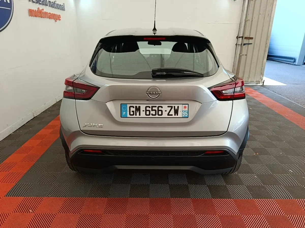Vue arrière d'un Nissan Juke gris clair 2023 avec feux LED et plaque d'immatriculation française visible.