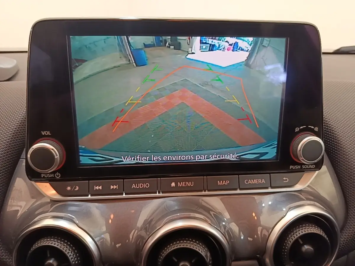 Écran tactile central montrant la caméra de recul avec lignes de guidage, intérieur gris clair du Nissan Juke 2023.