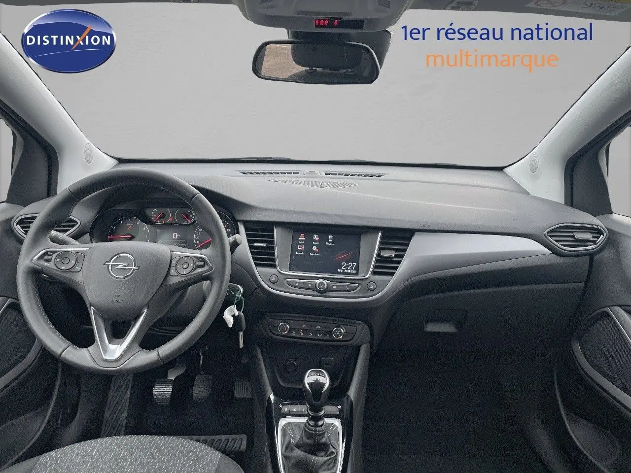 Vue intérieure avant de l'Opel Crossland 2022, tableau de bord noir avec écran tactile et levier de vitesse manuel.