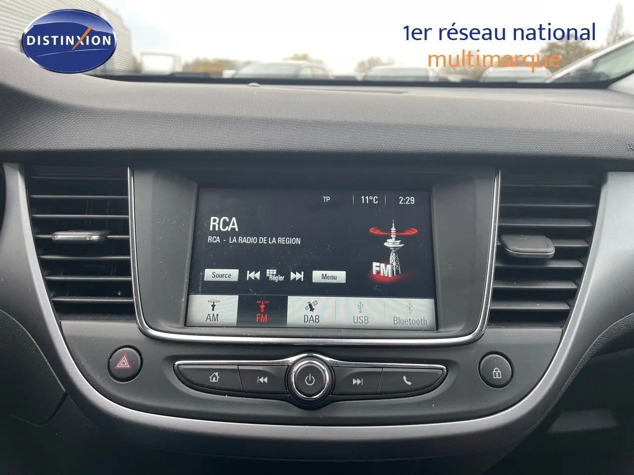 Vue rapprochée du tableau de bord de l'Opel Crossland gris minéral, avec écran tactile affichant la radio FM.