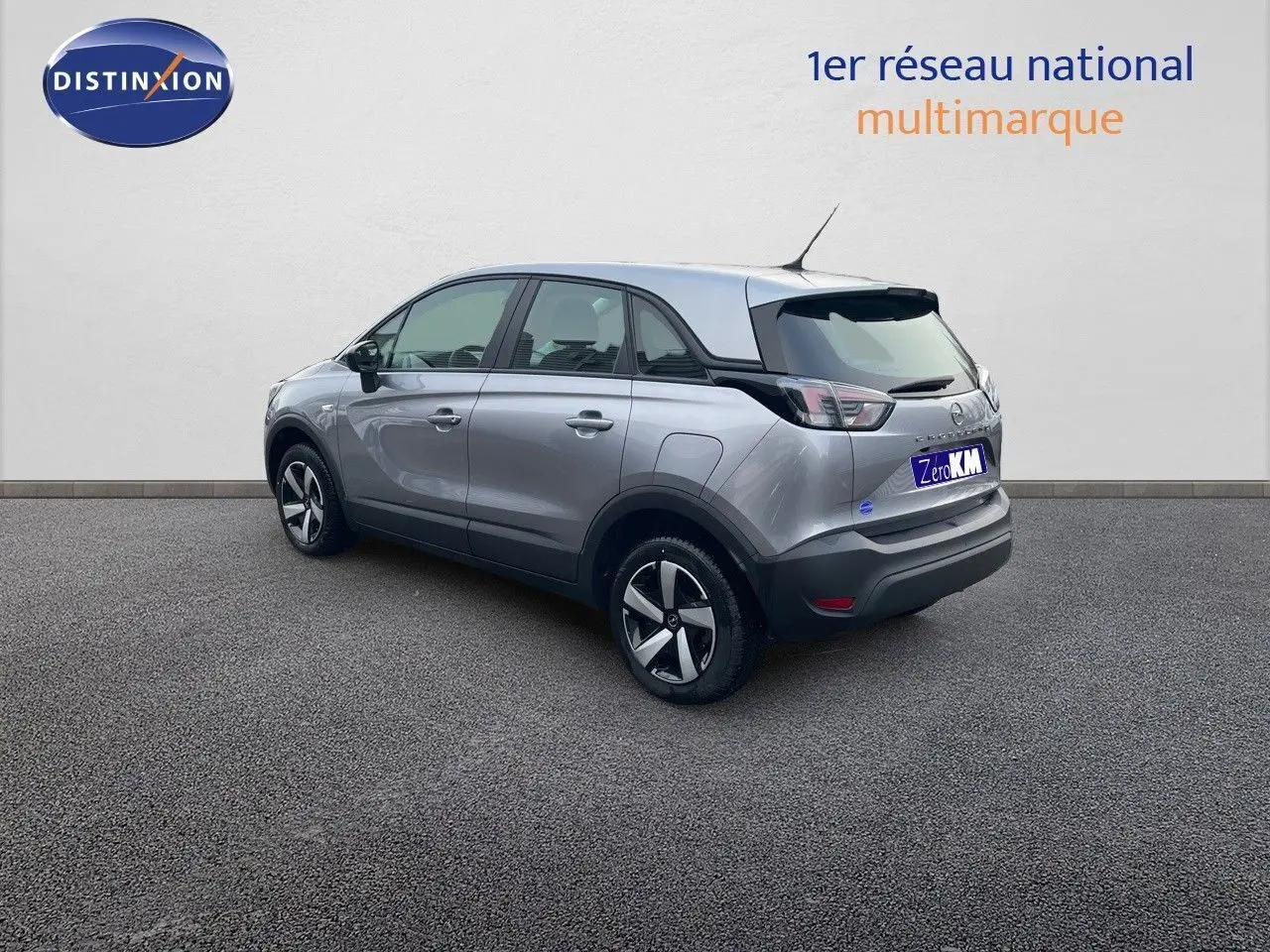 Opel Crossland gris minéral métal vu en 3/4 arrière côté gauche, avec jantes alliage et toit noir contrasté.