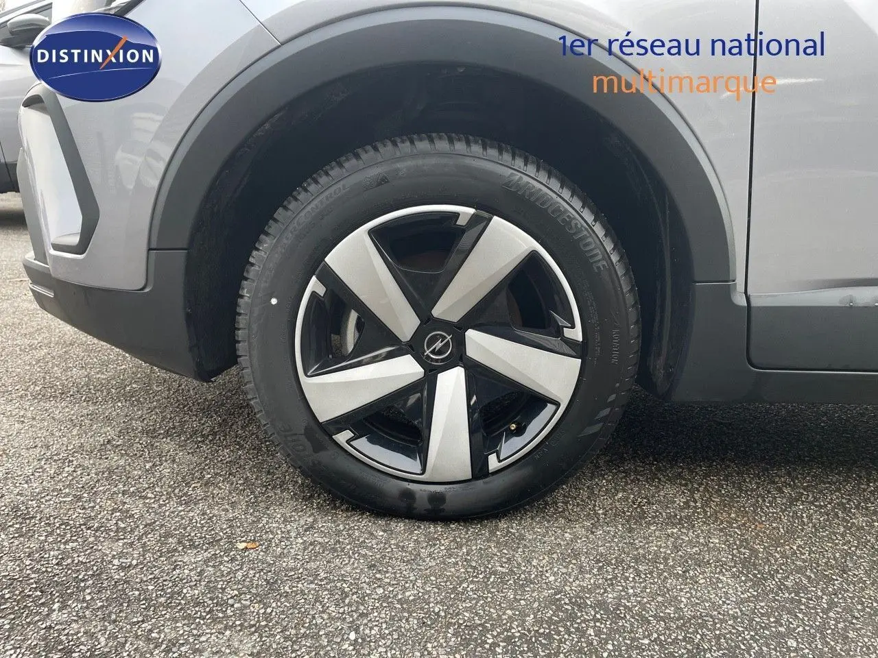 Gros plan sur la roue avant gauche de l'Opel Crossland gris minéral métal avec jante alliage bicolore moderne.