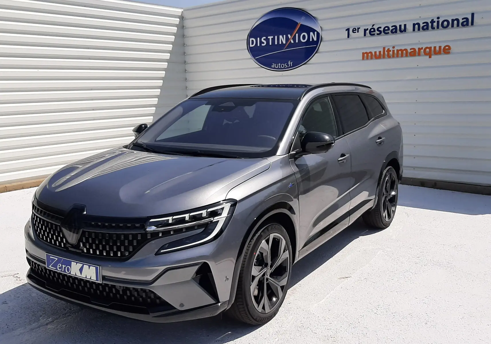 Renault Espace VI gris schiste métal en 3/4 avant droit, avec toit panoramique et jantes noires distinctives.