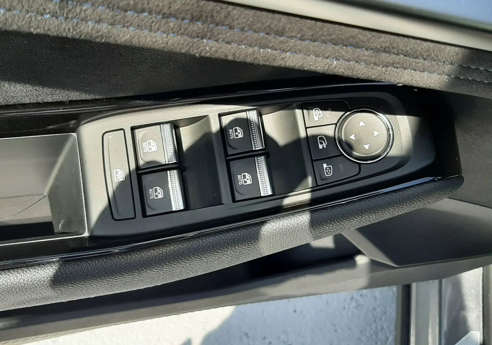 Gros plan sur les commandes des vitres et rétroviseurs côté gauche d'une Renault Espace gris schiste 2025.