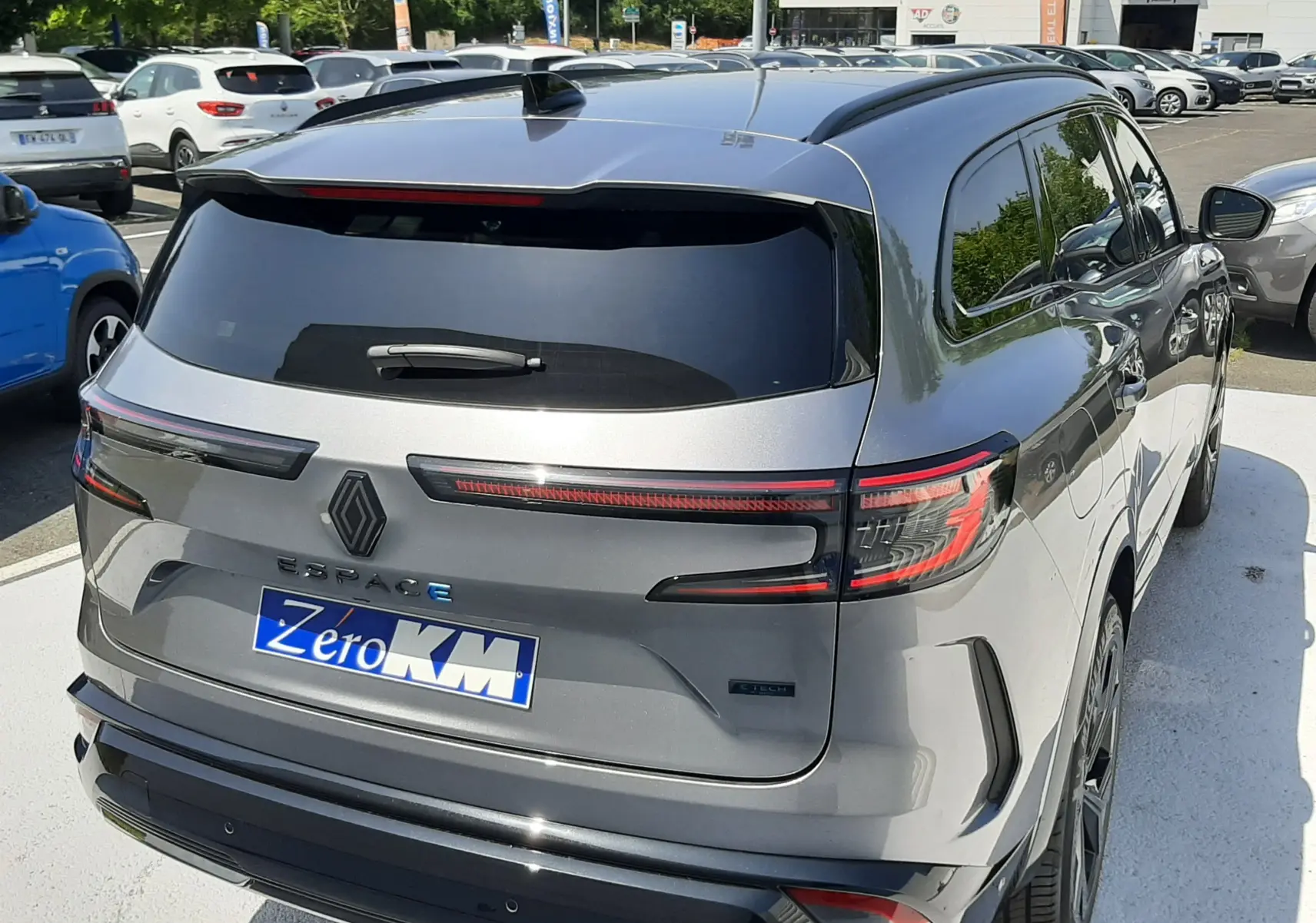 Vue 3/4 arrière droite d'un Renault Espace VI gris schiste métal avec feux arrière LED et toit panoramique.