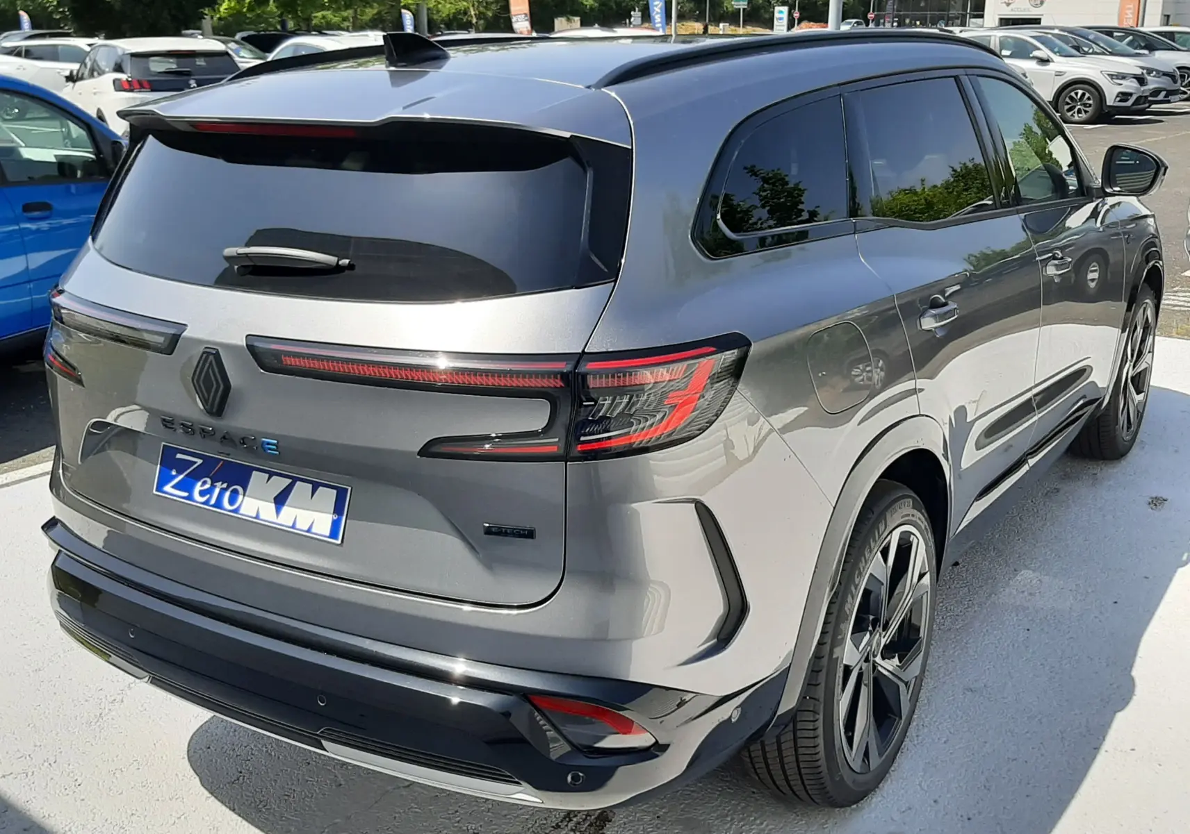 Vue 3/4 arrière droite d'un Renault Espace gris schiste métal 2025 avec feux arrière LED et jantes noires.