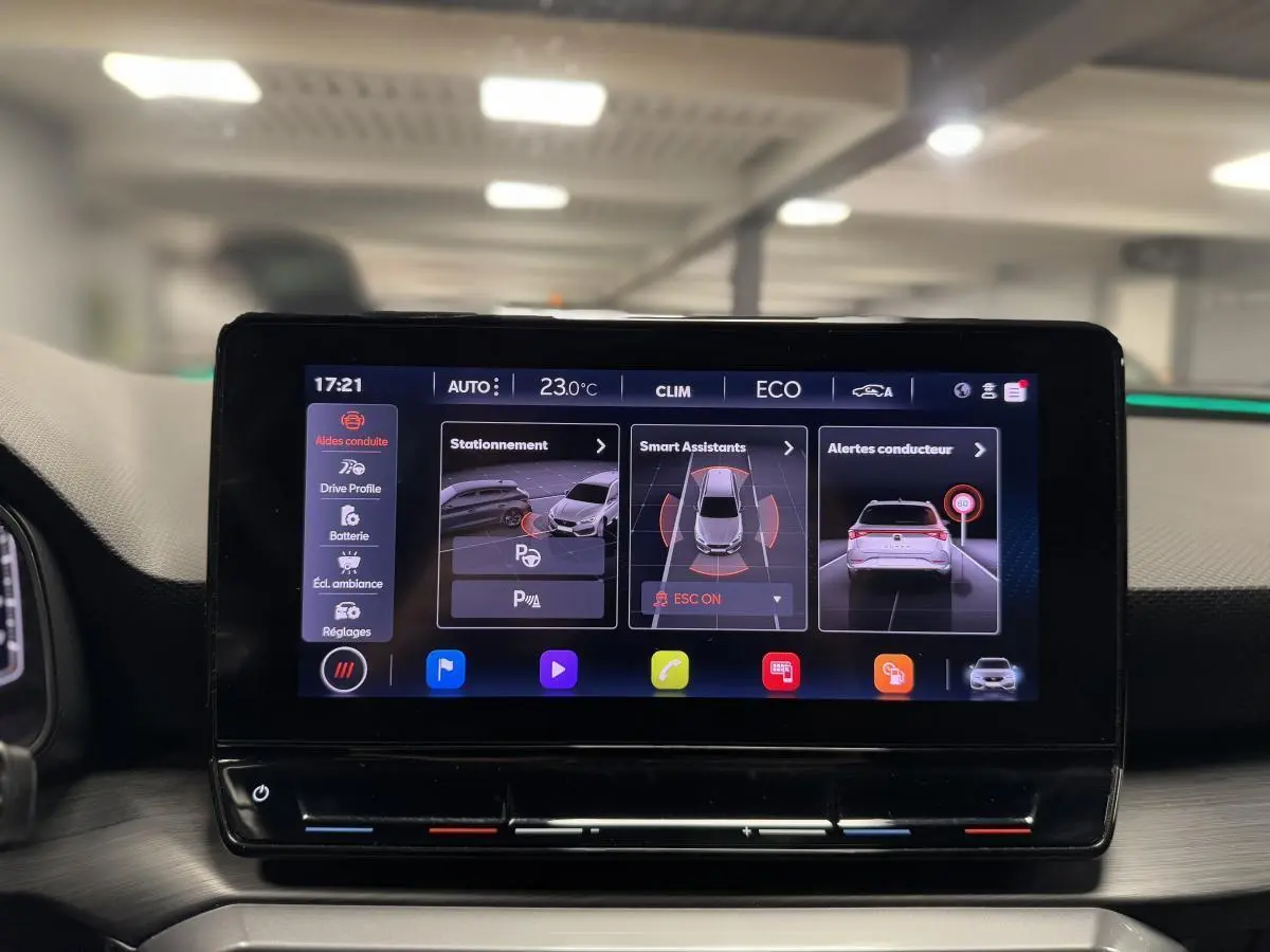 Écran tactile central affichant les aides à la conduite dans l'habitacle du CUPRA Leon Sportstourer rouge.