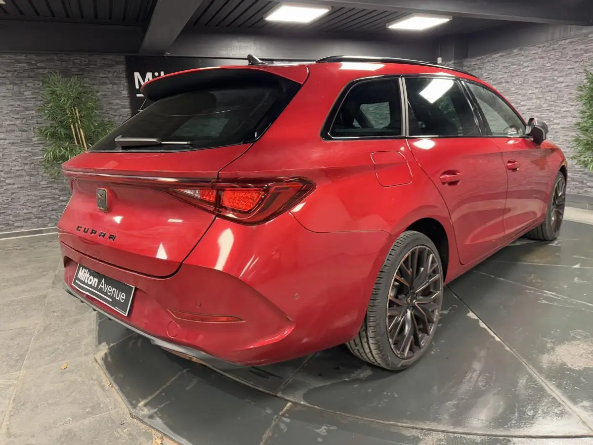 Vue 3/4 arrière droite d'une CUPRA Leon Sportstourer rouge Désir avec jantes alliage 19 pouces et vitres arrière surteintées.