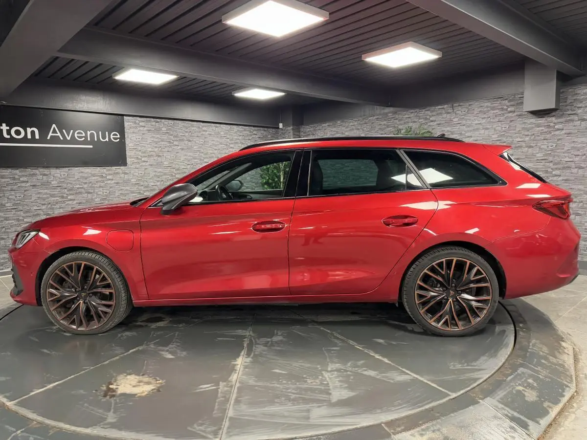 Profil côté gauche d'une CUPRA Leon Sportstourer rouge Désir avec jantes alliage 19 pouces Palm Springs.