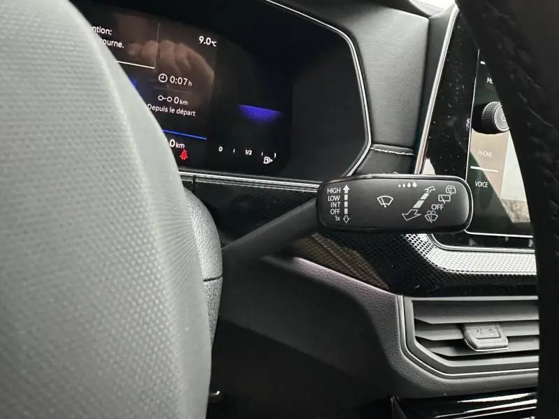 Gros plan sur la commande des essuie-glaces à droite du volant dans l'habitacle du Volkswagen T-Cross Gris Ascot 2025.
