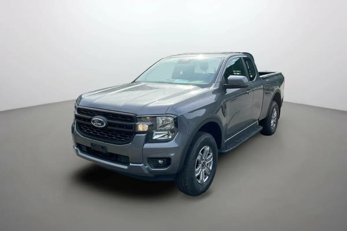 Ford Ranger gris carbone en 3/4 avant droit avec marchepieds latéraux et calandre noire distinctive.