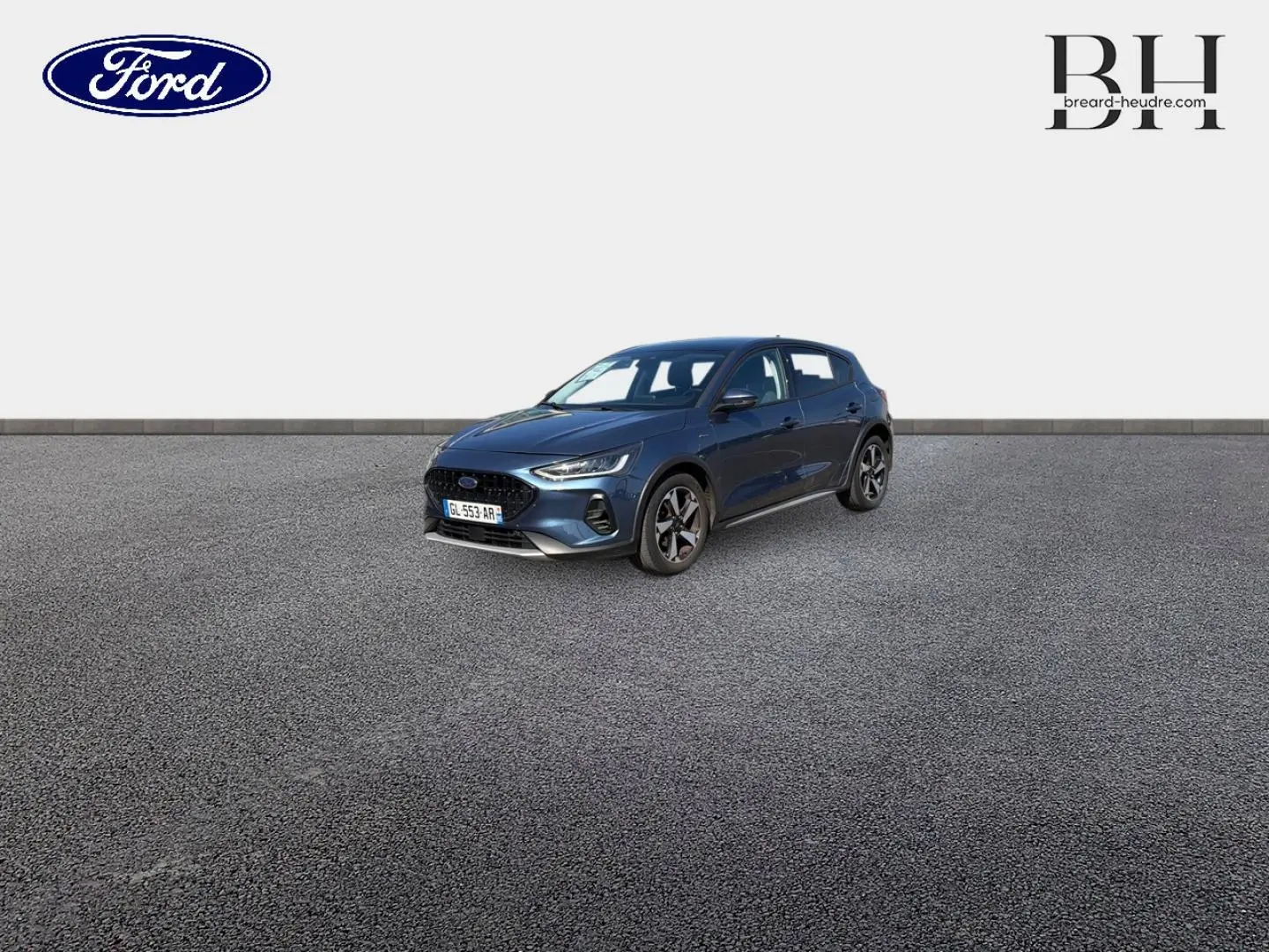 Ford Focus 1.0 Flexifuel bleu azur métallisé vue 3/4 avant droit sur sol gris, calandre noire et jantes alu.