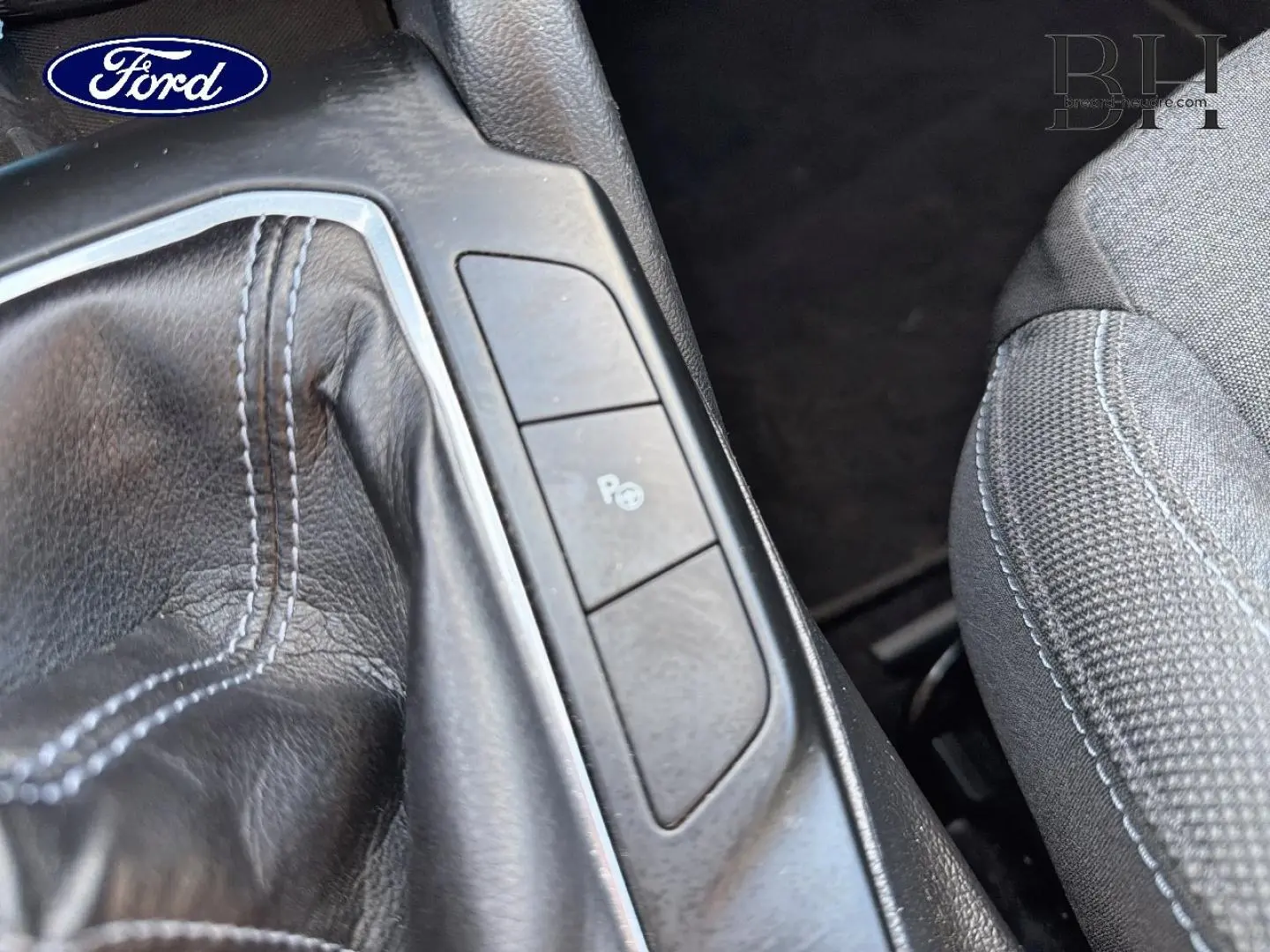 Gros plan sur la console centrale d’une Ford Focus 2022, montrant le soufflet de levier de vitesse cuir et boutons de parking.