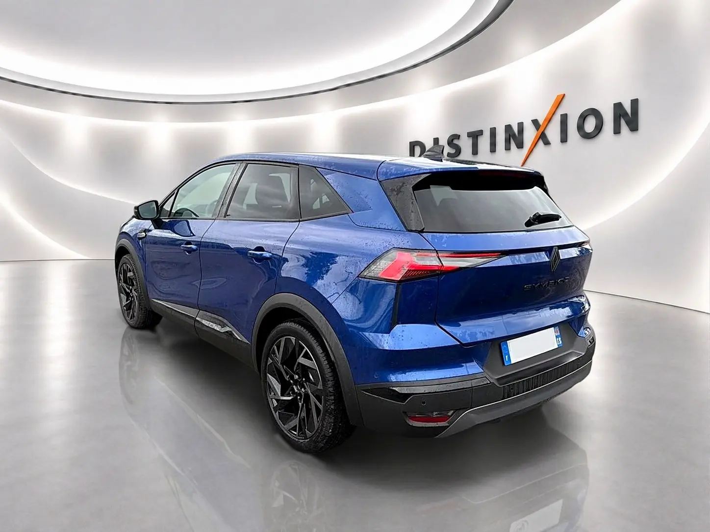 Vue 3/4 arrière droite du Renault Symbioz bleu iron avec jantes noires et feux arrière LED distinctifs.