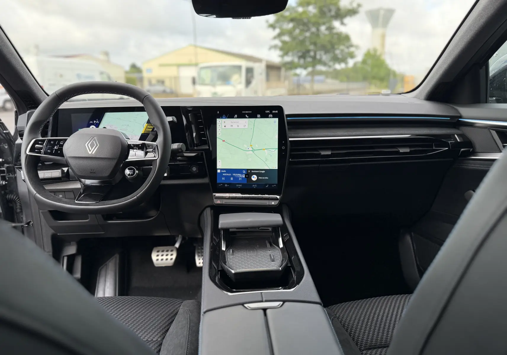 Intérieur moderne du Renault Espace 2025, vue avant centrée sur le tableau de bord noir avec écran tactile vertical.