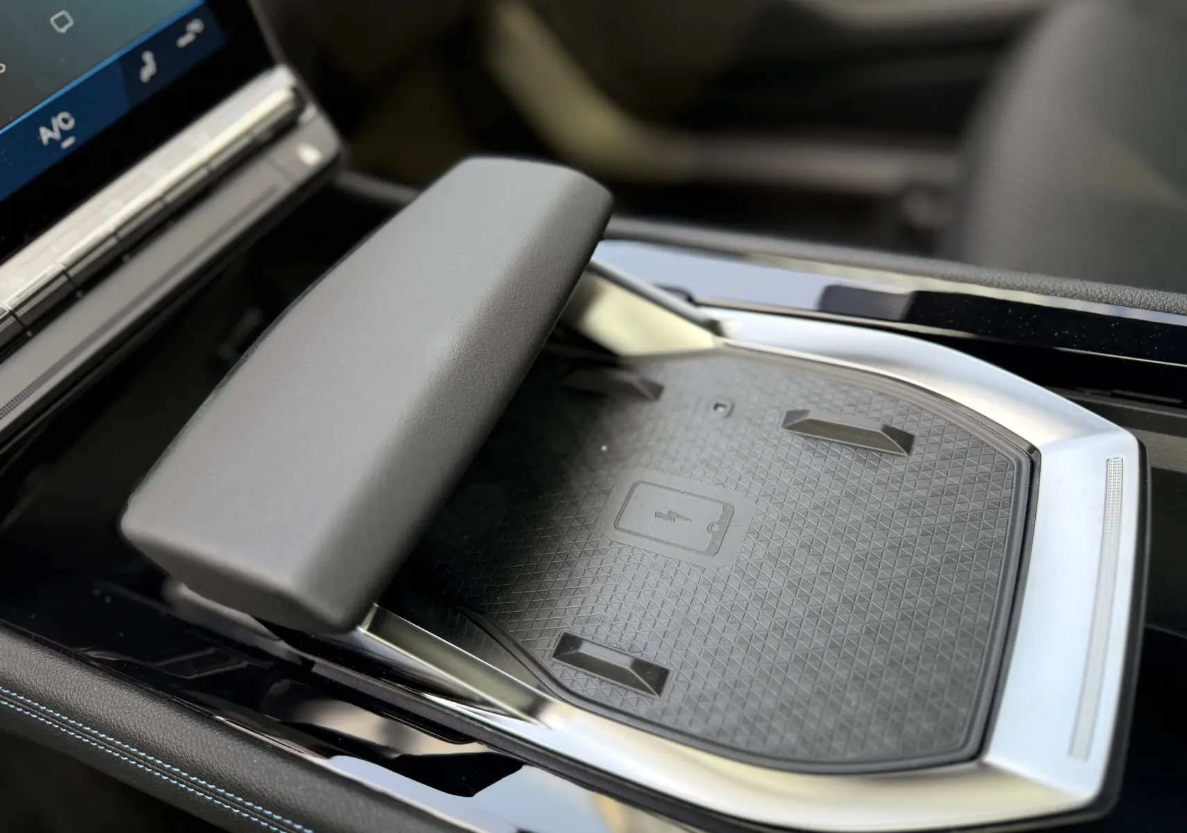 Plateau de recharge sans fil et accoudoir en cuir noir dans le console centrale du Renault Espace 2025 gris schiste métal.