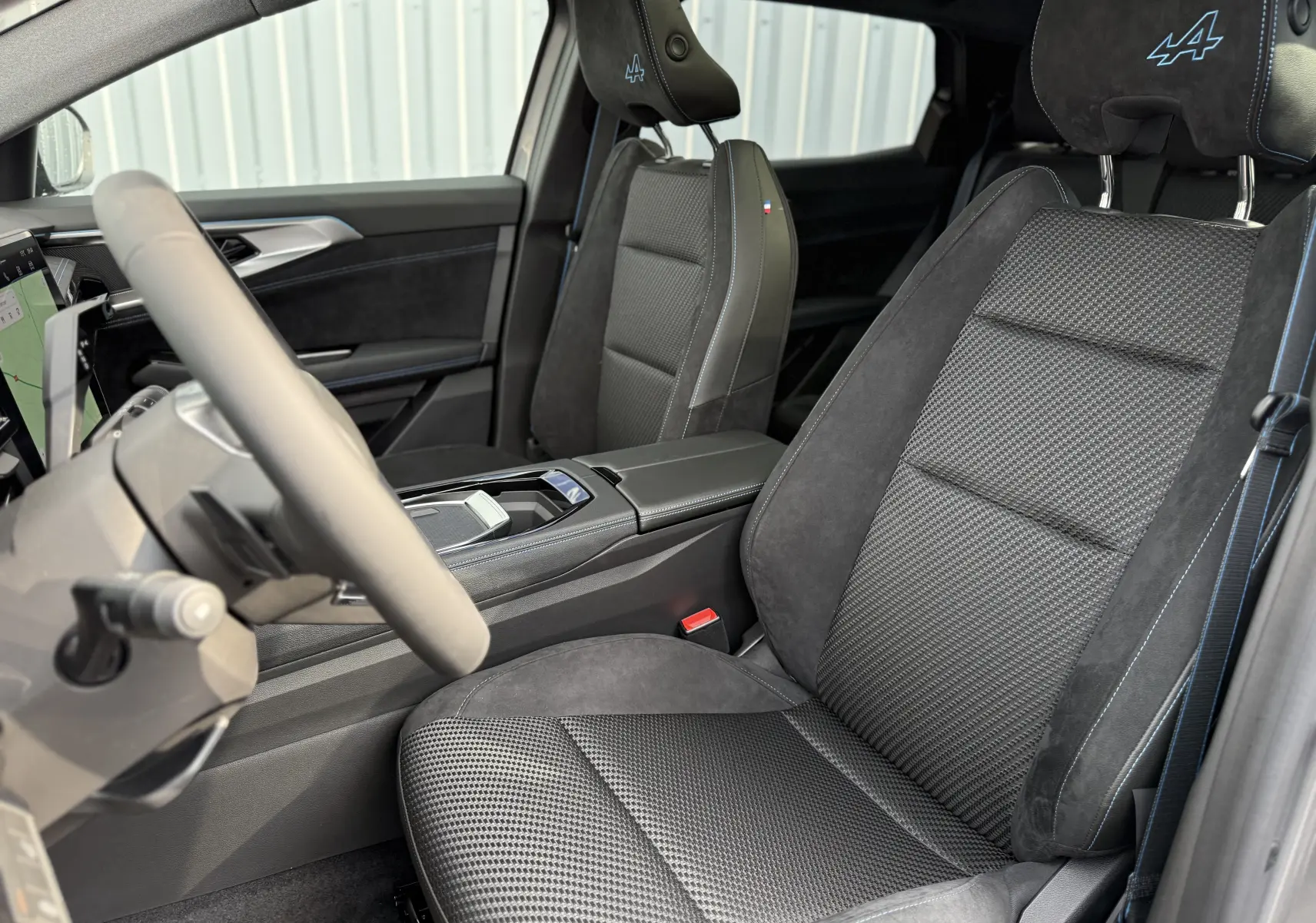 Vue intérieure côté conducteur du Renault Espace 2025, sièges noirs avec logo Alpine brodé sur les appuie-têtes.