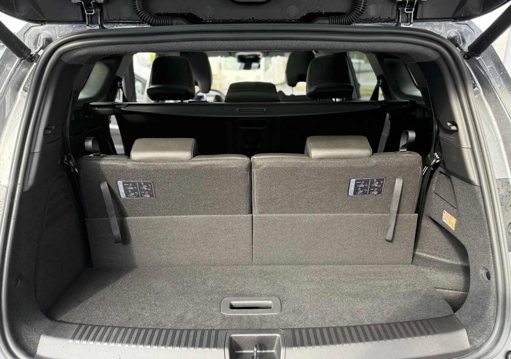 Coffre ouvert vu de l'arrière d'un Renault Espace gris schiste, montrant la troisième rangée de sièges relevée.
