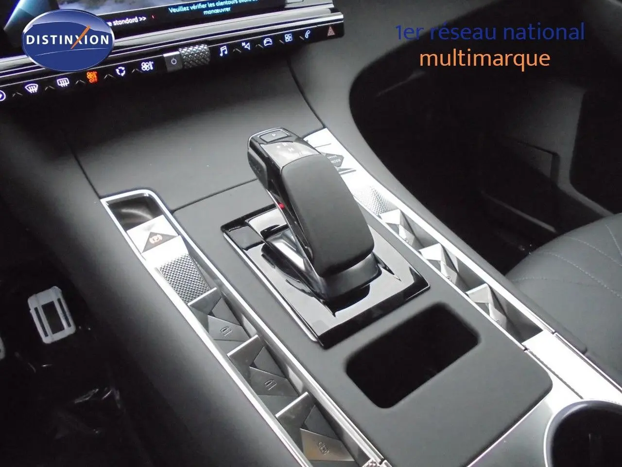 Vue rapprochée de la console centrale noire perle métal du DS7 Crossback E-TENSE avec levier de vitesses automatique et boutons triangulaires.