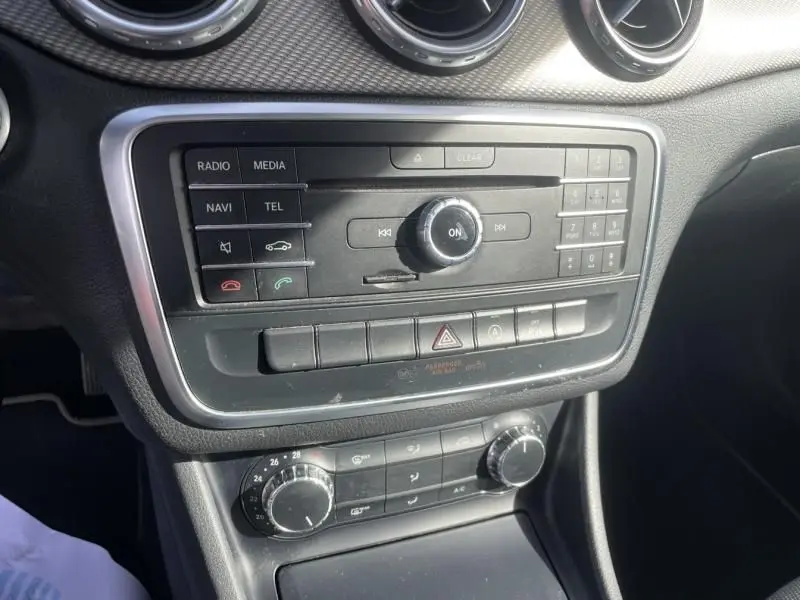 Vue rapprochée de la console centrale noire du Mercedes GLA 200 D Sensation 2017 avec commandes multimédia et climatisation.